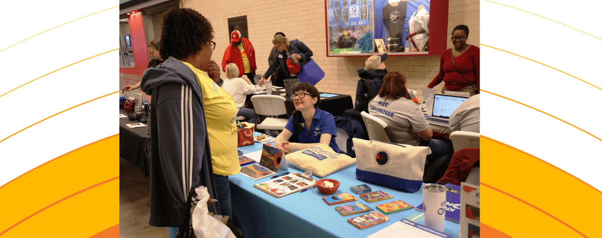 Agency representatives talk to people attending the volunteer expo