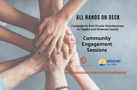 People's hands meet one on top of another over a grey background