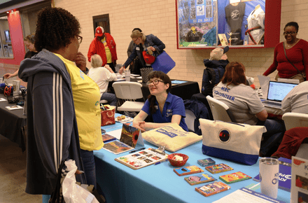 Agency representatives talk to people attending the volunteer expo